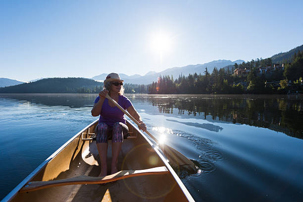 istock Senior aged woman canoeing on a pristine lake 578594054