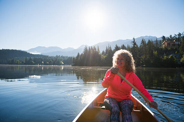 istock Senior aged woman canoeing on a pristine lake 578594192