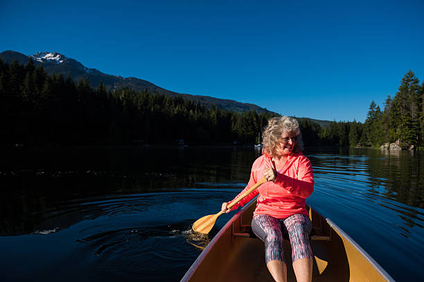 istock Senior aged woman canoeing on a pristine lake 578594220