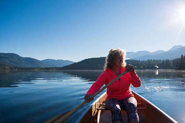 istock Senior aged woman canoeing on a pristine lake 578594258