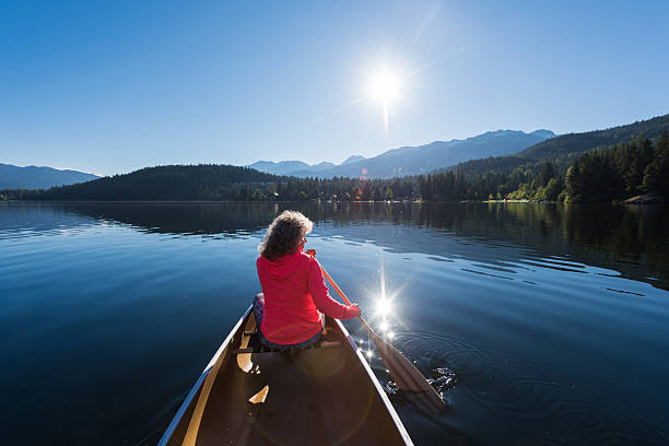 istock Senior aged woman canoeing on a pristine lake 578594384