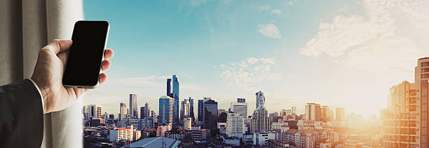 istock Hand holding mobile phone with panoramic cityscape, vintage tone 578594782