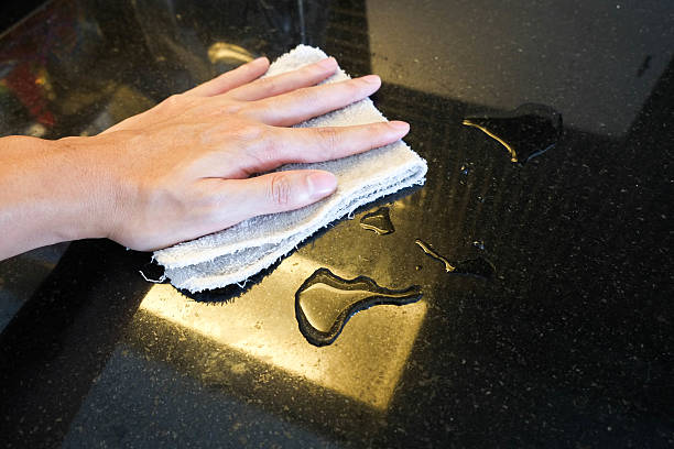 istock Hand wiping black marble stone counter bar 578595130