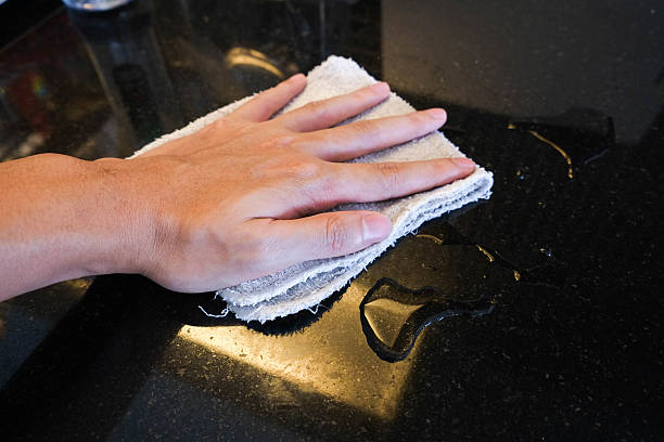 istock Hand wiping black marble stone counter bar 578595140