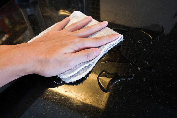 istock Hand wiping black marble stone counter bar 578595148