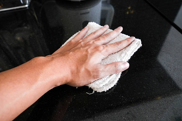 Hand wiping black marble stone counter bar