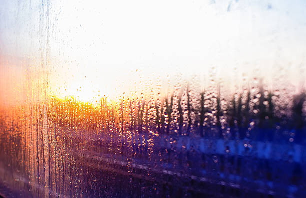 istock water drops on glass  train on background setting sun railroad 578596200
