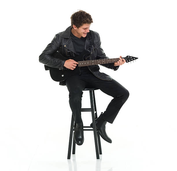 souriant homme jouant de la guitare - isolated on white studio shot guitar young men photos et images de collection