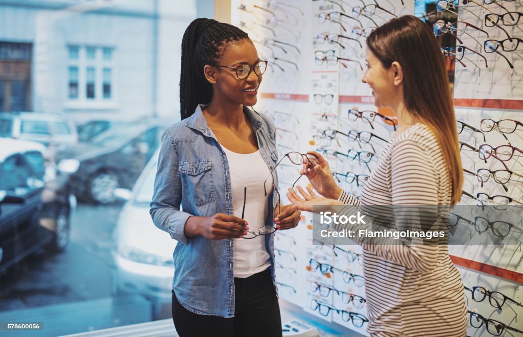 African American woman in an optometrist African American woman in an optometrist store being assisted in the purchase of a pair of frames for her eyeglasses Optometrist Stock Photo