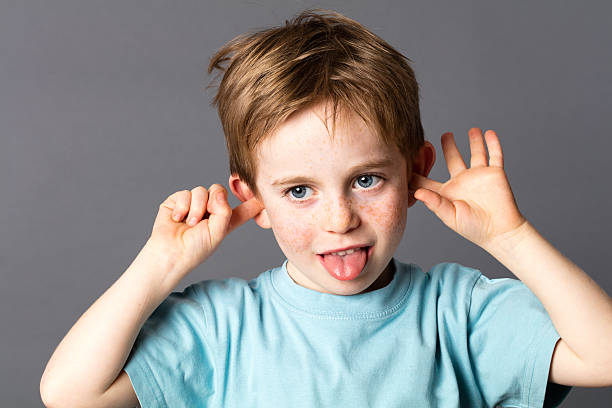 istock bored little boy ignoring, sticking out his tongue for misbehavior 578600724