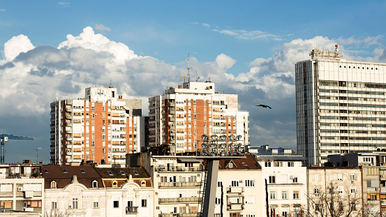 Urban old buildings with white fluffy clouds on the blue sky
