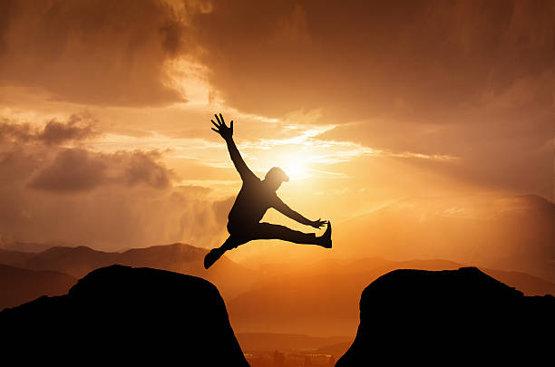 istock Silhouette of a jumping  man on summit 578789844