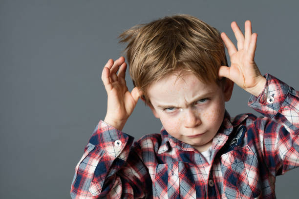 istock rude kid playing with hands making face for determined attitude 578791878