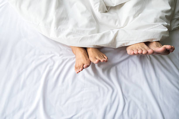 istock Feet of couple in comfortable bed. 578799314