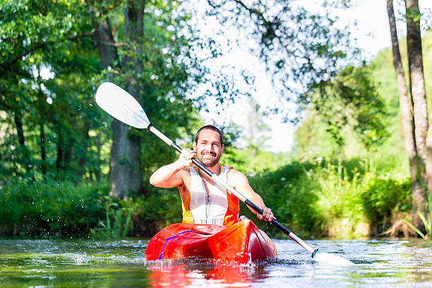 istock Man paddling with canoe on forest river 578799960