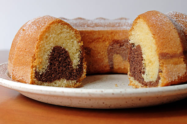 Homemade marble cake with cocoa sprinkled with sugar on a wooden table