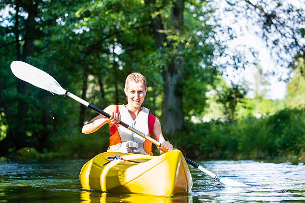 istock Woman paddling with canoe on forest river 578800232