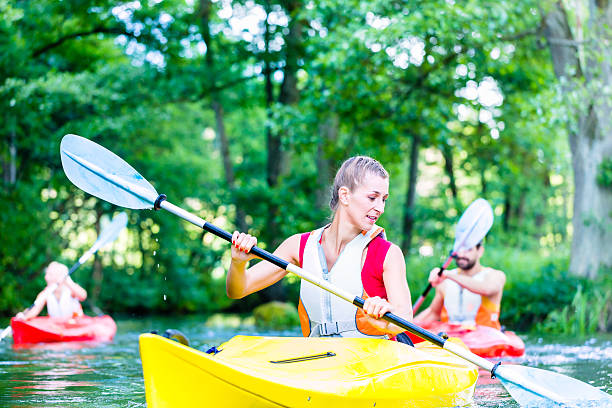istock Friends paddling with canoe on forest river 578800542