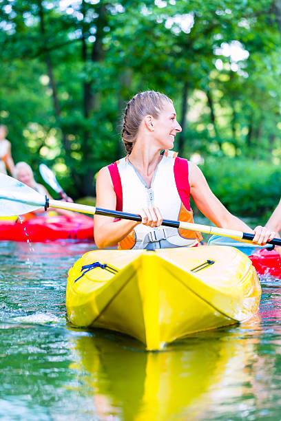 istock Woman paddling with canoe on forest river 578800616
