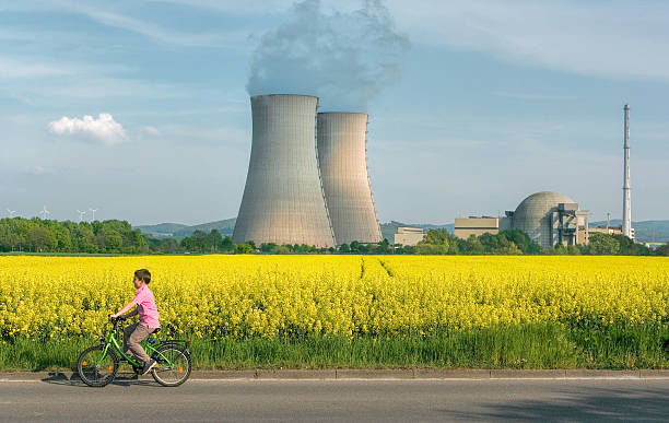 menino de bicicleta na frente de centrais nucleares - nuclear power station nuclear energy child nuclear reactor - fotografias e filmes do acervo