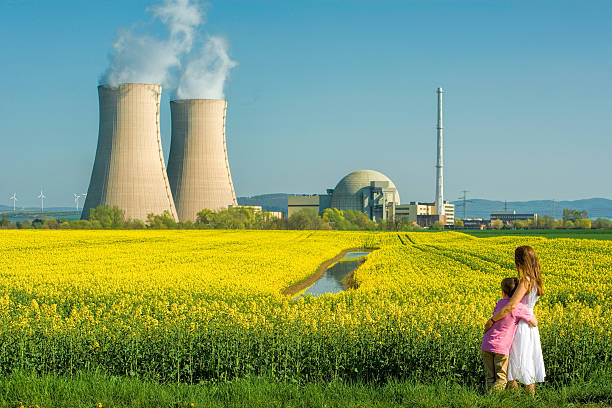 madre che abbraccia son davanti alla centrale nucleare - nuclear power station nuclear energy child nuclear reactor foto e immagini stock