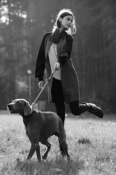 fashion girl model walk with her dog outdoor park nature stock photo
