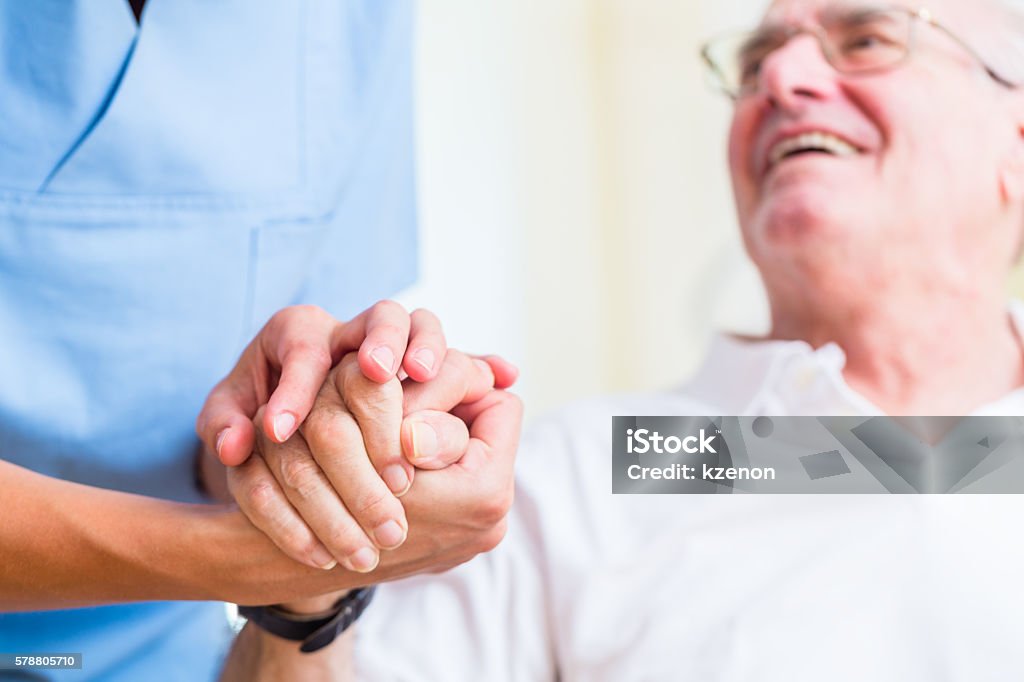 Anziano e infermiere di vecchiaia in casa di cura - Foto stock royalty-free di Uomini anziani