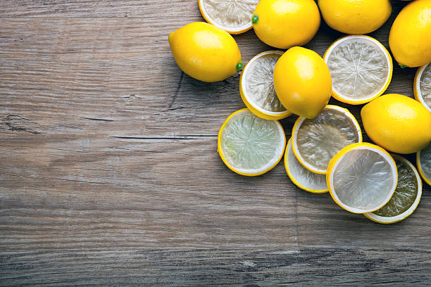 istock Fresh ripe lemons on wooden board background with copy space 578805766