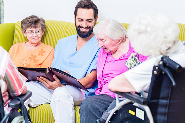 istock Geriatric nurse looking at pictures with seniors 578805914