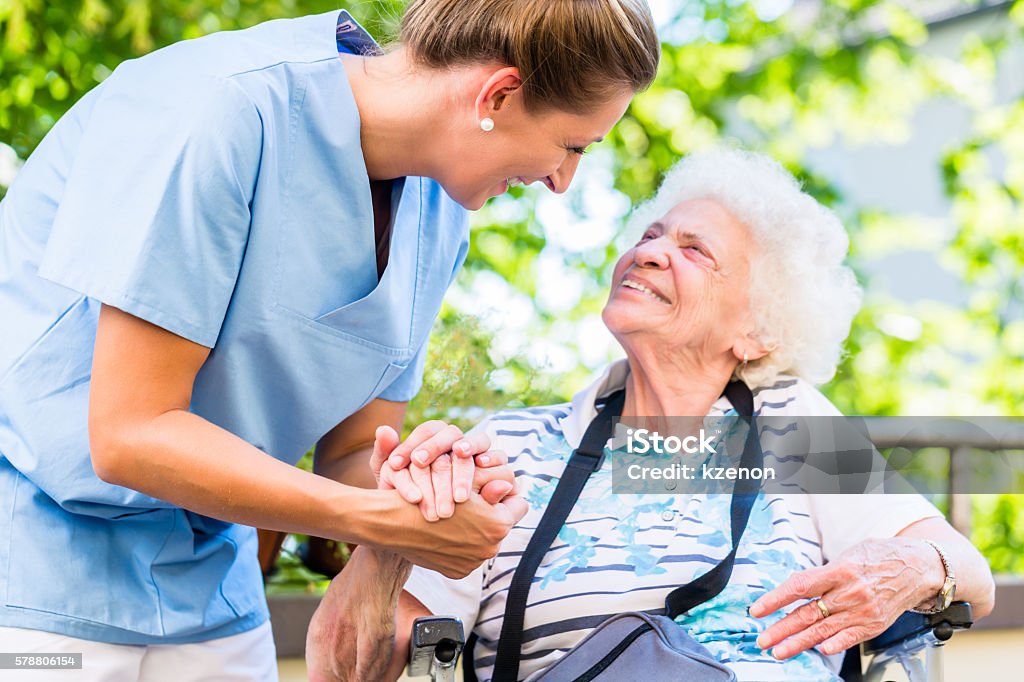 Nurse holding hand of senior woman in pension home Senior Adult Stock Photo