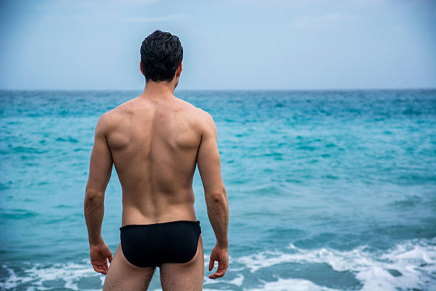 istock Back view of man in trunks against seascape 578808018