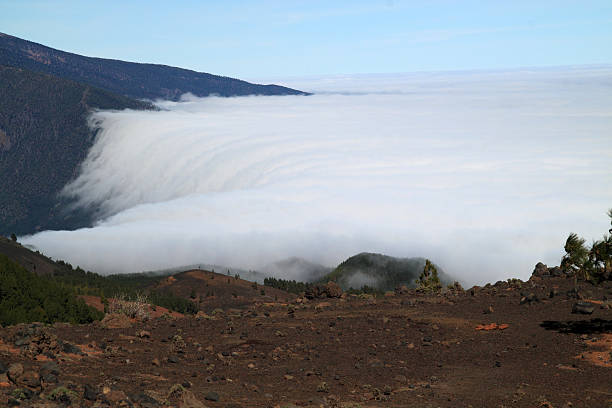 istock Creeping clouds collide with the volcano rim 578809412