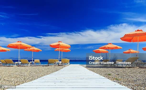 White Wooden Walkway Leading To Beach With Umbrellas And Sunbeds Stock Photo - Download Image Now