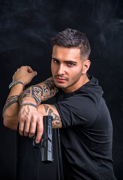 joven con pistola de mano - tattoo gun fotografías e imágenes de stock