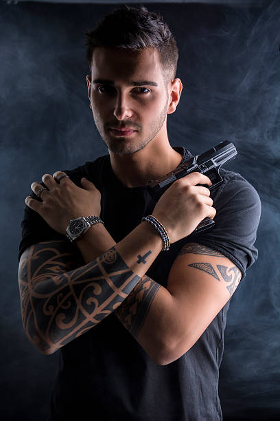 joven con pistola de mano - tattoo gun fotografías e imágenes de stock