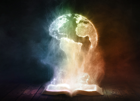 An open book glows brightly and reveals a globe of the world.