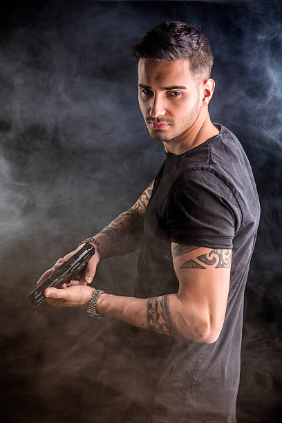 joven con pistola de mano - tattoo gun fotografías e imágenes de stock