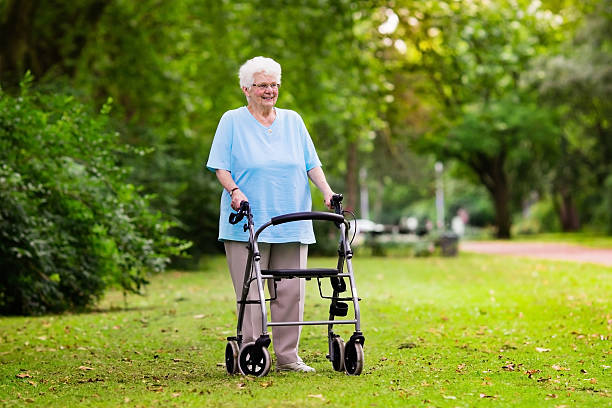 istock Senior lady with a walker in a sunny park 578815478
