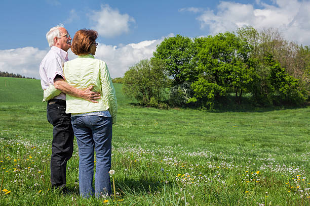 istock Senior couple standing on blooming meadow in spring 578815958