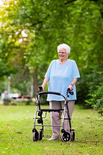 istock Senior lady with a walker in sunny park 578816984