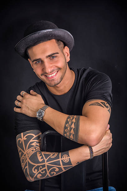 istock Young man with black bowler hat and tattoos 578817728