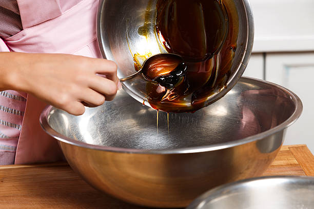 Young woman holding metal bowl and spoon, and cooking stock photo