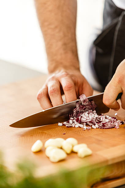 istock Knife chopping red onion on cutting board 578823540