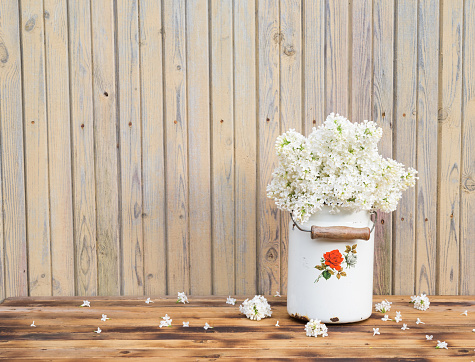 Bouquet of white lilac spring flowers on wooden table. Vintage floral background.