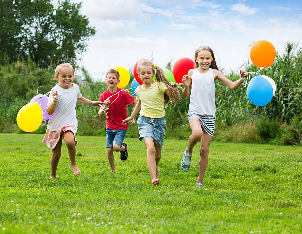 istock Children running and holding balloons 578824584