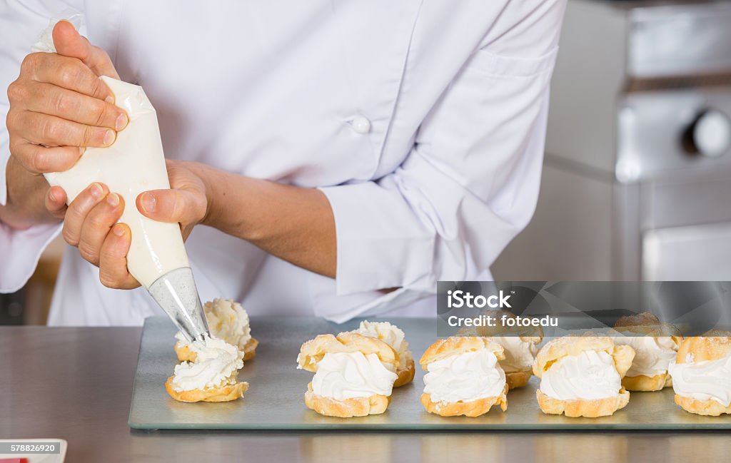 Pastry chef decorating Pastry chef decorating with a sleeve profiteroles Icing Bag Stock Photo