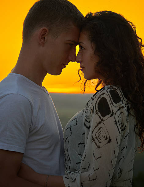istock young couple at sunset on sky background, love concept 578827490
