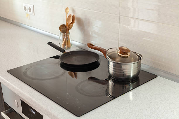 istock Wooden spoons in modern kitchen with induction stove 578827632