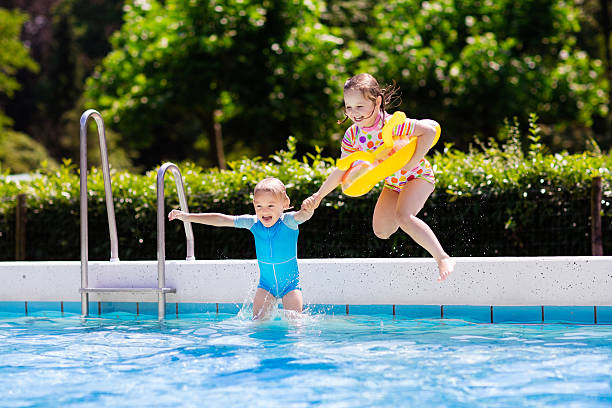 istock Kids jumping into swimming pool 578828278