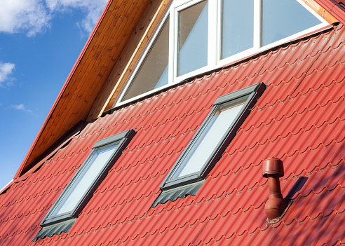 New red metal roof with windows (skylights) and ventilator for heat control